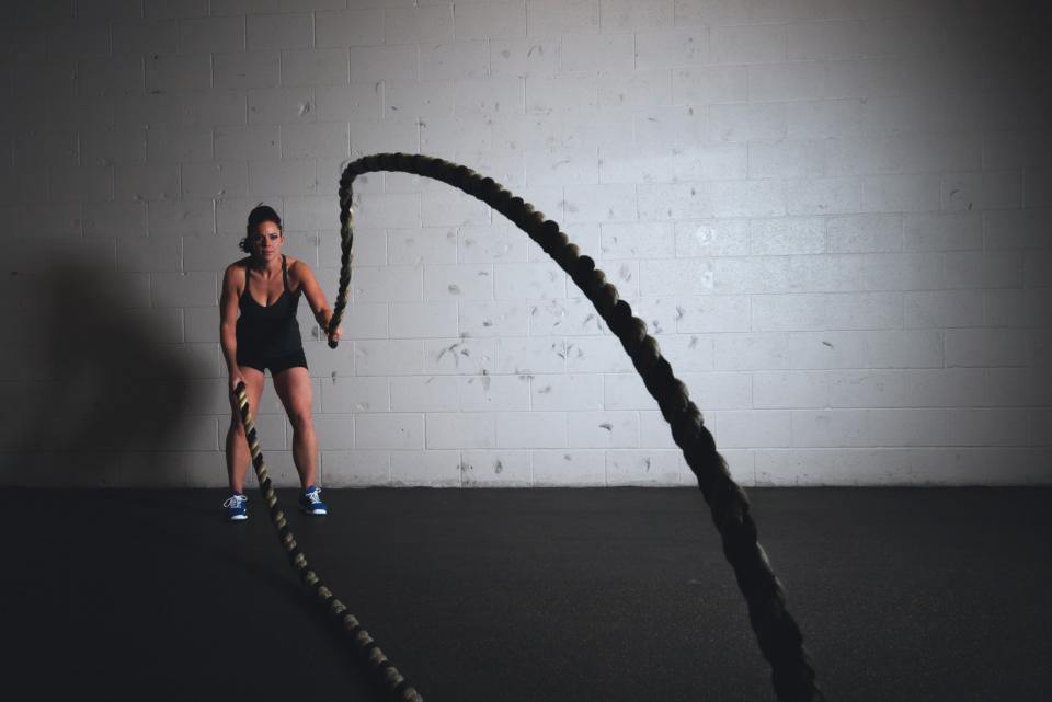 Atleta entrenando con cuerdas de batalla